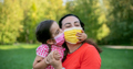 little girl wearing face mask kisses her mother